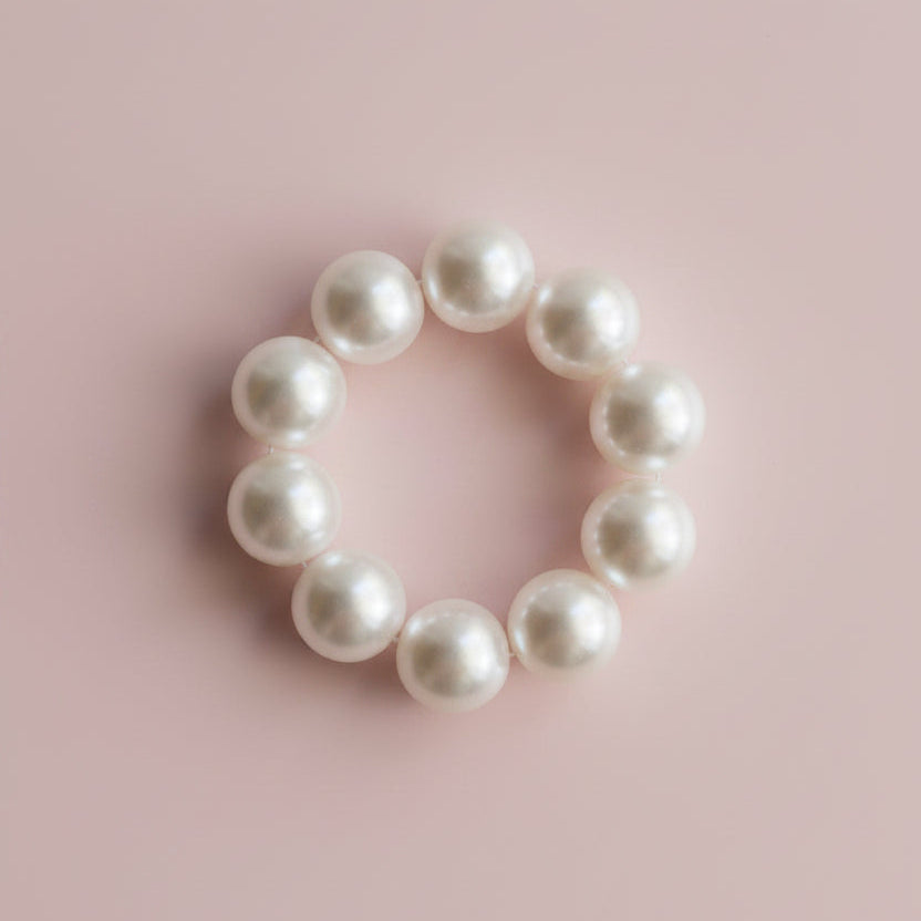 Pearl bracelet on a light wooden surface