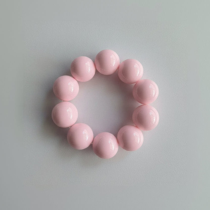 Pink beaded bracelet on a light wooden surface